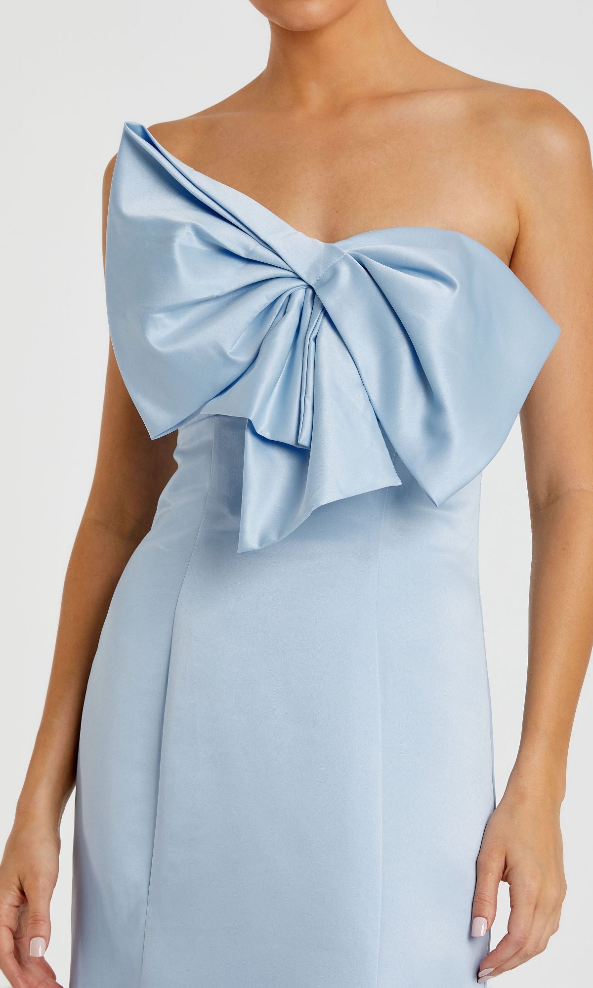 A woman wearing the Mac Duggal 49701 strapless mermaid formal dress in light blue, featuring a large bow detail on the bodice.